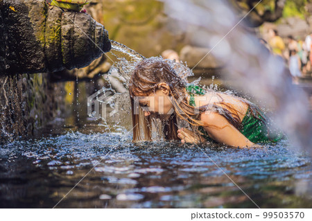 Woman in holy spring water temple in bali. The temple compound consists of a petirtaan or bathing structure, famous for its holy spring water Woman in holy spring water temple in bali. The temple compound consists of a petirtaan or bathing structure, famous for its holy spring water 99503570