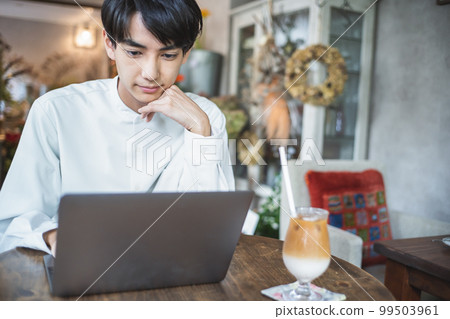 Young man using a computer in a cafe 99503961