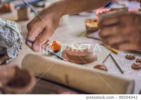 Father and son doing ceramic pot in pottery workshop Father and son doing ceramic pot in pottery workshop 99504042