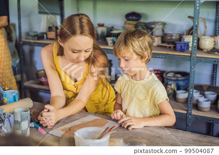 mother and son doing ceramic pot in pottery workshop mother and son doing ceramic pot in pottery workshop 99504087