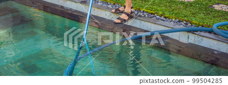 Cleaner of the swimming pool . Man in a blue shirt with cleaning equipment for swimming pools. Pool cleaning services BANNER, LONG FORMAT 99504285