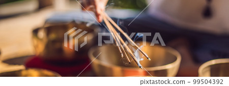 Woman playing on Tibetan singing bowl while sitting on yoga mat against a waterfall. Vintage tonned. Beautiful girl with mala beads meditating BANNER, LONG FORMAT Woman playing on Tibetan singing bowl while sitting on yoga mat against a waterfall. Vintage tonned. Beautiful girl with mala beads meditating BANNER, LONG FORMAT 99504392
