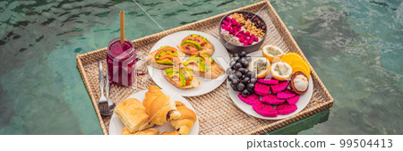 BANNER, LONG FORMAT Breakfast tray in swimming pool, floating breakfast in luxury hotel smoothies and fruit plate, smoothie bowl by the hotel pool. Exotic summer diet. Tropical beach lifestyle. Bali BANNER, LONG FORMAT Breakfast tray in swimming pool, floating breakfast in luxury hotel smoothies and fruit plate, smoothie bowl by the hotel pool. Exotic summer diet. Tropical beach lifestyle. Bali 99504413
