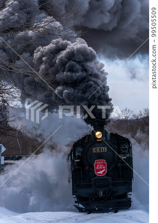 Steam locomotive Fuyu-no-Shitsugen goes around corners while raising black smoke and splashing snow. 99505509