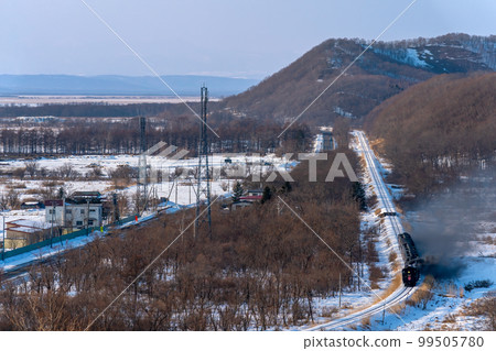 Steam locomotive Fuyu no Shitsugen-go runs through the scenery with a view of Mt. Akan 99505780