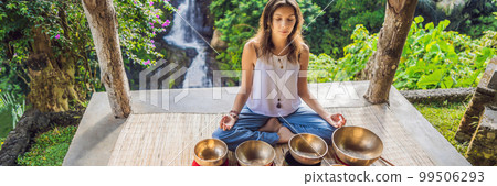 Woman playing on Tibetan singing bowl while sitting on yoga mat against a waterfall. Vintage tonned. Beautiful girl with mala beads meditating BANNER, LONG FORMAT Woman playing on Tibetan singing bowl while sitting on yoga mat against a waterfall. Vintage tonned. Beautiful girl with mala beads meditating BANNER, LONG FORMAT 99506293