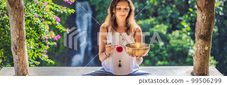 Woman playing on Tibetan singing bowl while sitting on yoga mat against a waterfall. Vintage tonned. Beautiful girl with mala beads meditating BANNER, LONG FORMAT Woman playing on Tibetan singing bowl while sitting on yoga mat against a waterfall. Vintage tonned. Beautiful girl with mala beads meditating BANNER, LONG FORMAT 99506299