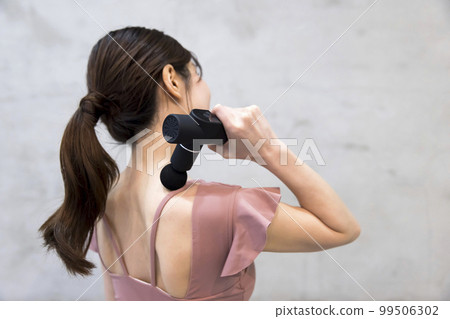 使用肌筋膜釋放槍的女人手中的一把方便的槍 99506302