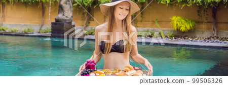BANNER, LONG FORMAT Breakfast tray in swimming pool, floating breakfast in luxury hotel. Girl relaxing in the pool drinking smoothies and eating fruit plate, smoothie bowl by the hotel pool. Exotic BANNER, LONG FORMAT Breakfast tray in swimming pool, floating breakfast in luxury hotel. Girl relaxing in the pool drinking smoothies and eating fruit plate, smoothie bowl by the hotel pool. Exotic 99506326