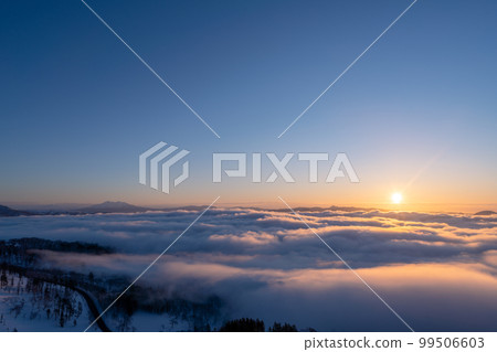 Sunrise over Lake Kussharo seen from Bihoro Pass and a sea of clouds dyed in the color of the morning sun 99506603