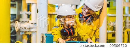 BANNER, LONG FORMAT Young man and a little boy are both in a yellow work uniform, glasses, and helmet in an industrial environment, oil Platform or liquefied gas plant BANNER, LONG FORMAT Young man and a little boy are both in a yellow work uniform, glasses, and helmet in an industrial environment, oil Platform or liquefied gas plant 99506710