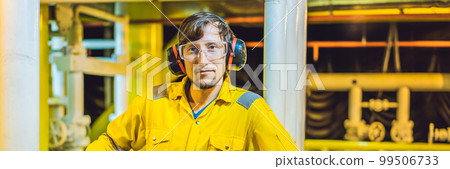 Young man in a yellow work uniform, glasses and helmet in industrial environment,oil Platform or liquefied gas plant BANNER, LONG FORMAT Young man in a yellow work uniform, glasses and helmet in industrial environment,oil Platform or liquefied gas plant BANNER, LONG FORMAT 99506733