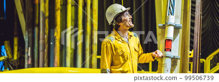 Young man in a yellow work uniform, glasses and helmet in industrial environment,oil Platform or liquefied gas plant BANNER, LONG FORMAT Young man in a yellow work uniform, glasses and helmet in industrial environment,oil Platform or liquefied gas plant BANNER, LONG FORMAT 99506739