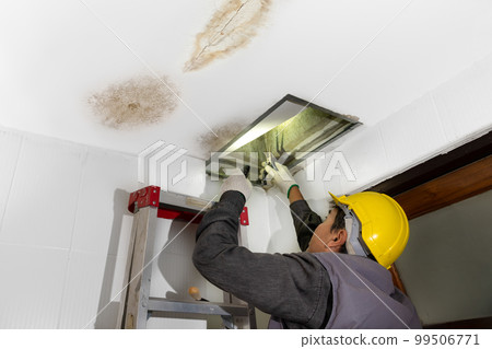 Worker fix leaking pipe in ceiling ,close-up of a stain on the ceiling. 99506771