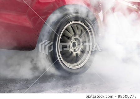Drag racing car burning tire at starting line in race track Drag racing car burning tire at starting line in race track 99506775