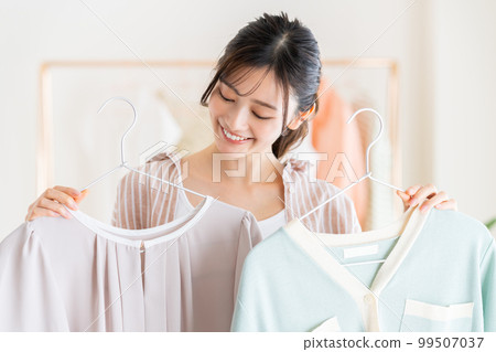 A young woman choosing clothes A young woman choosing clothes 99507037