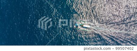 Sea bay with turquoise water and a small white beach. Beautiful lagoon and volcanic island covered with dense forest, view from above BANNER, LONG FORMAT 99507402