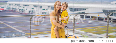 BANNER, LONG FORMAT Family at airport before flight. Mother and son waiting to board at departure gate of modern international terminal. Traveling and flying with children. Mom with kid boarding 99507454