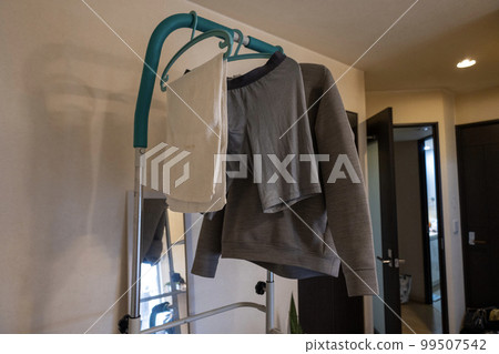 Laundry hung in a hanging health container in the room Laundry hung in a hanging health container in the room 99507542