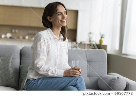 Positive cheerful young woman holding glass of pure natural water 99507778