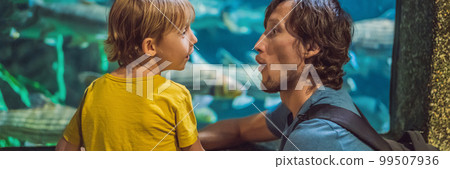 Father and son looking at fish in a tunnel aquarium BANNER, LONG FORMAT Father and son looking at fish in a tunnel aquarium BANNER, LONG FORMAT 99507936