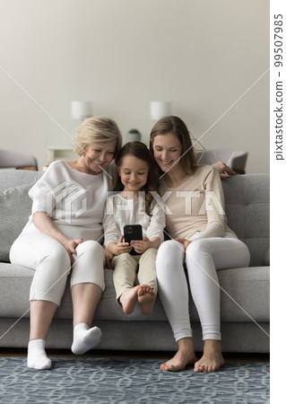 Happy girls and women of different generations using mobile phone Happy girls and women of different generations using mobile phone 99507985