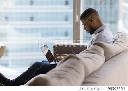 Busy focused young business man working at home, using laptop 99508264