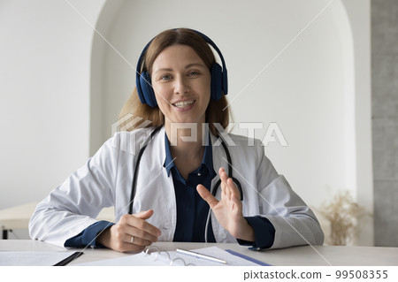 Happy practitioner in wireless head phones speaking on video call Happy practitioner in wireless head phones speaking on video call 99508355