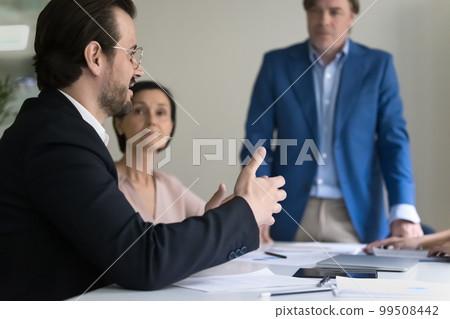 Engaged handsome business employee man talking to colleagues on meeting 99508442