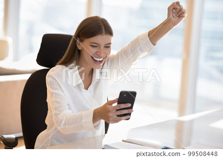 Cheerful satisfied young freelance business woman celebrating win 99508448