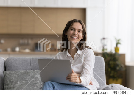 Happy freelance business woman holding laptop, sitting on couch 99508461