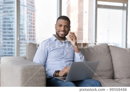 Cheerful busy handsome millennial freelance entrepreneur talking on mobile phone Cheerful busy handsome millennial freelance entrepreneur talking on mobile phone 99508486