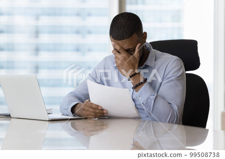 Shocked upset business man reading legal document, getting bad news 99508738