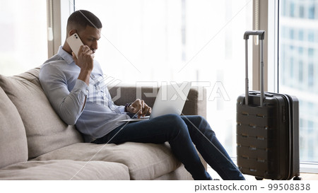Busy young millennial travelling business man using digital gadgets 99508838