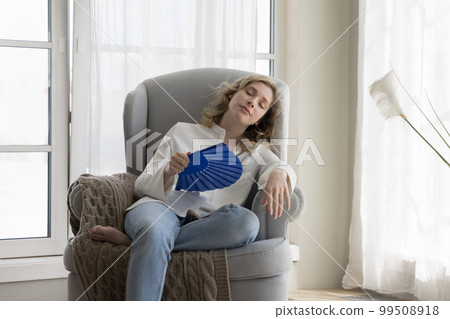 Tired relaxed beautiful young woman suffering from heat Tired relaxed beautiful young woman suffering from heat 99508918