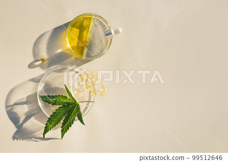 Cannabis leaves, CBD oil in pipette and capsules on a laboratory background 99512646
