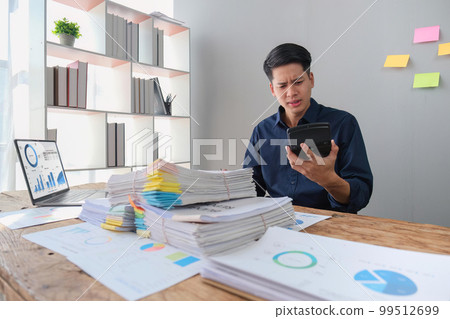 Hand of stress young asian businessman,male is pressing a calculator to calculate tax income and expenses, bills, credit card for payment or payday at home, office.Financial, finance concept Hand of stress young asian businessman,male is pressing a calculator to calculate tax income and expenses, bills, credit card for payment or payday at home, office.Financial, finance concept 99512699