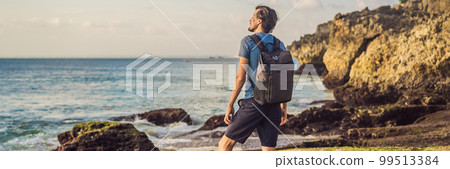 Young man tourist on Pantai Tegal Wangi Beach, Bali Island, Indonesia. Bali Travel Concept BANNER, LONG FORMAT 99513384