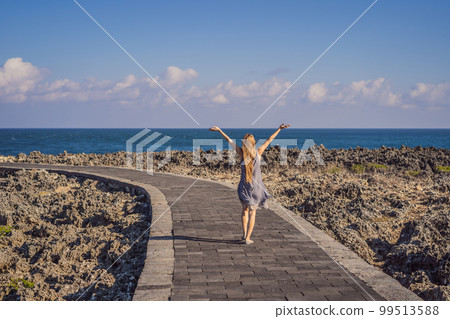 Young woman on the rocks in Bali, Nusadua, Waterbloom Fountain 99513588