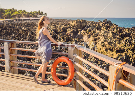 Young woman on the rocks in Bali, Nusadua, Waterbloom Fountain 99513620