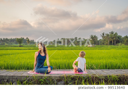Boy and his yoga teacher doing yoga in a rice field Boy and his yoga teacher doing yoga in a rice field 99513640