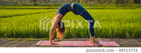 Young woman practice yoga outdoor in rice fields in the morning during wellness retreat in Bali BANNER, LONG FORMAT 99513758