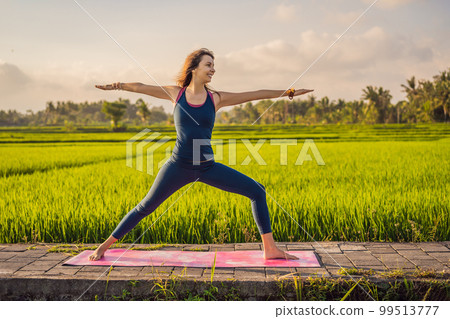 Young woman practice yoga outdoor in rice fields in the morning during wellness retreat in Bali Young woman practice yoga outdoor in rice fields in the morning during wellness retreat in Bali 99513777