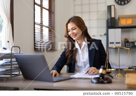 Attractive young lawyer in office Business woman and lawyers discussing contract papers with brass scale on wooden desk in office. Law, legal services, advice, Justice and real estate concept 99515790