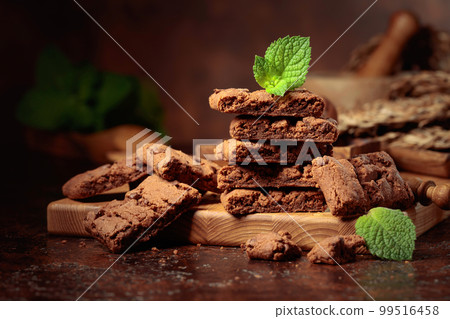 Brownie with mint on an old table with kitchen utensils. 99516458