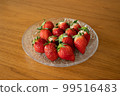 Fresh strawberries arranged in a glass bowl 99516483