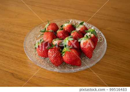 Fresh strawberries arranged in a glass bowl 99516483