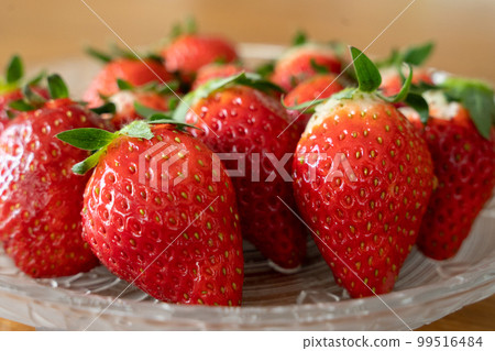 Fresh strawberries arranged in a glass bowl 99516484