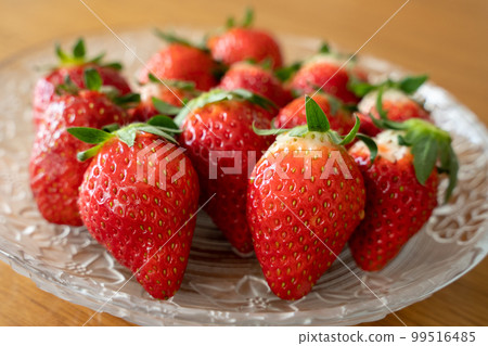 Fresh strawberries arranged in a glass bowl 99516485