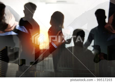 Handshaking business person in office. concept of teamwork and partnership. double exposure 99517203